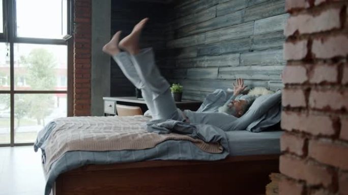 穿着睡衣的成熟男人的慢动作在家中独自享受休息