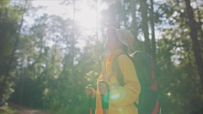 穿着黄色雨衣的女徒步旅行者和背包