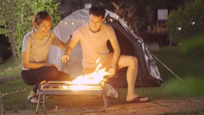 亚洲华人夫妇在他们的房屋后院建立消防露营周末活动