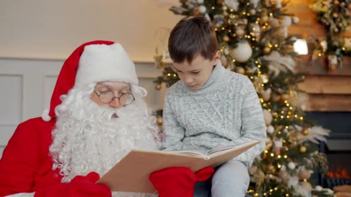 可爱的孩子和圣诞老人在圣诞树附近看书，并在元旦聊天