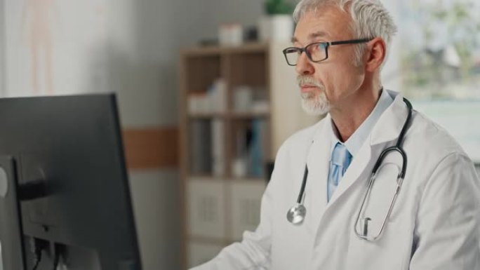 经验丰富的中年男医生穿着白大褂在办公室的个人电脑上工作。高级医疗保健专业人员，负责测试结果，患者治疗
