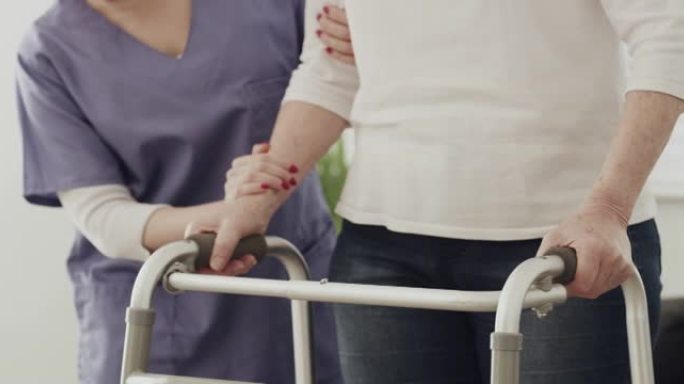4k视频片段，一名护士帮助患者使用步行架行走