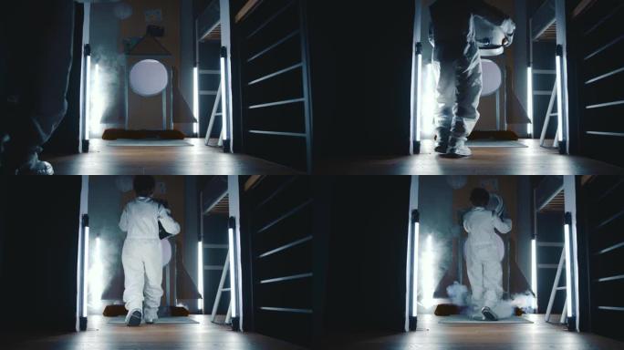 电影的后视图，穿着太空服的孩子走上神秘的黑暗太空飞船，上面覆盖着白色的烟雾。