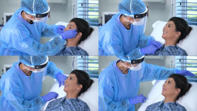 PPE中的护士为病床上的病人提供氧气