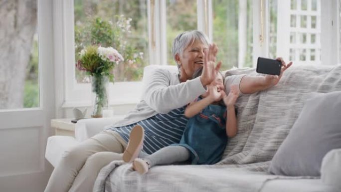 小女孩用智能手机和祖母在家庭分享假期周末挥手视频聊天和奶奶在手机上聊天和孙女4k在家放松