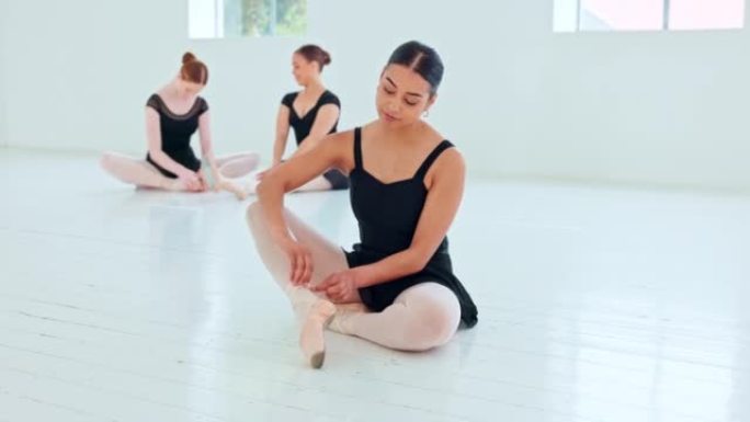 舞蹈课开始前，芭蕾舞鞋，工作室和芭蕾舞女演员系丝带。训练，练习和芭蕾舞演员坐在地板上，女孩准备表演，