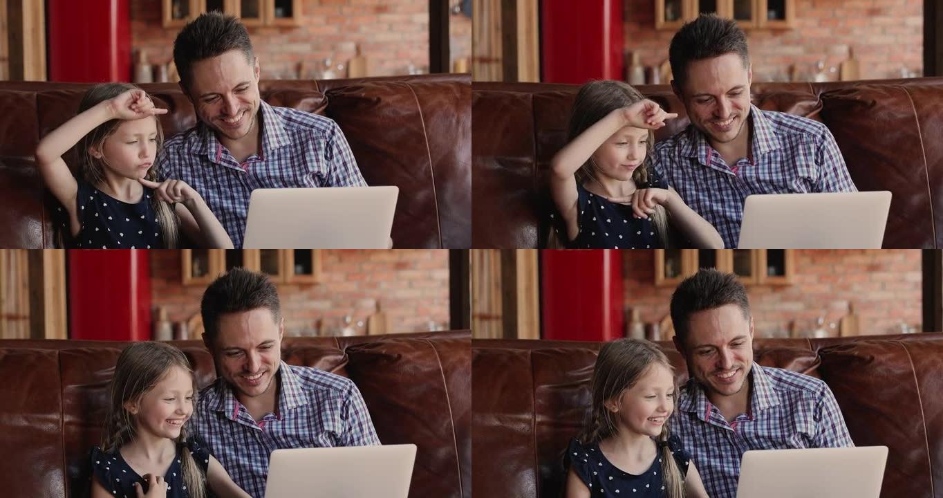 快乐的小女孩使用有趣的电脑应用程序与父亲。