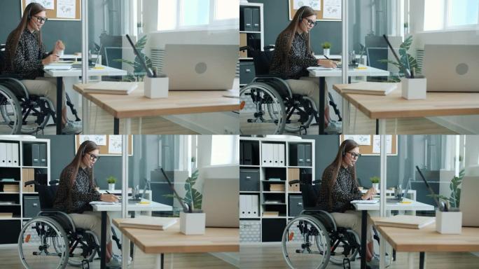 残疾上班族用笔记本电脑和耳机进行在线视频通话，坐在轮椅上写字