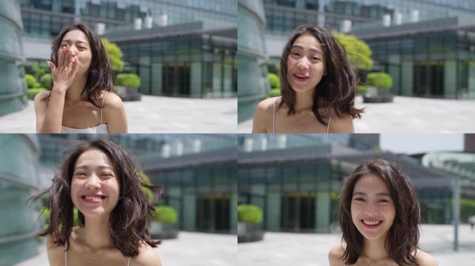 迷人的年轻亚洲女人看着镜头微笑在夏日城市慢动作说爱你可爱的女朋友