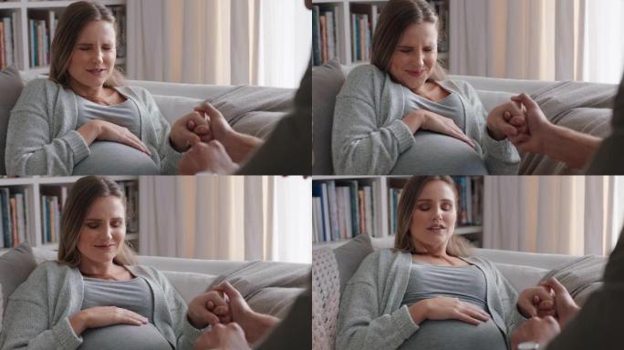 年轻的孕妇分娩有宫缩紧张的丈夫帮助妻子平静地呼吸怀孕疼痛在家沙发上放松