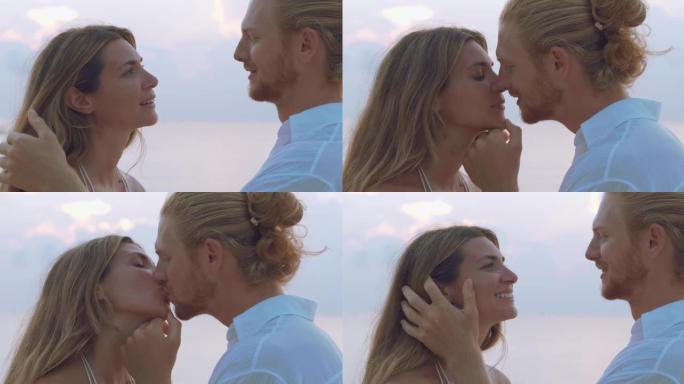 25-29岁的拉丁美洲和西班牙裔夫妇在沙滩上沿着日落海的边缘浪漫接吻。家庭假期快乐。非高加索蜜月概念