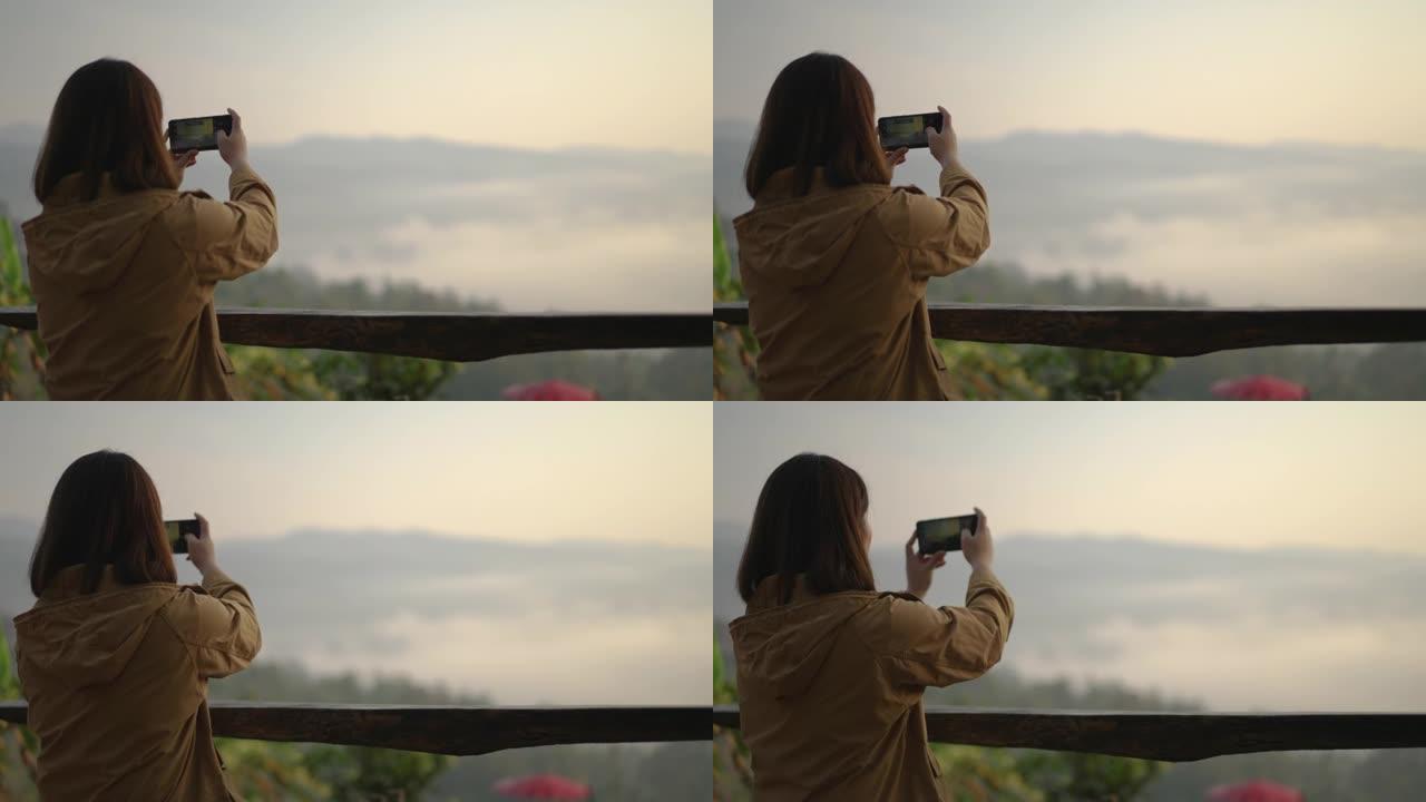 女人在山上放松，用智能手机拍照