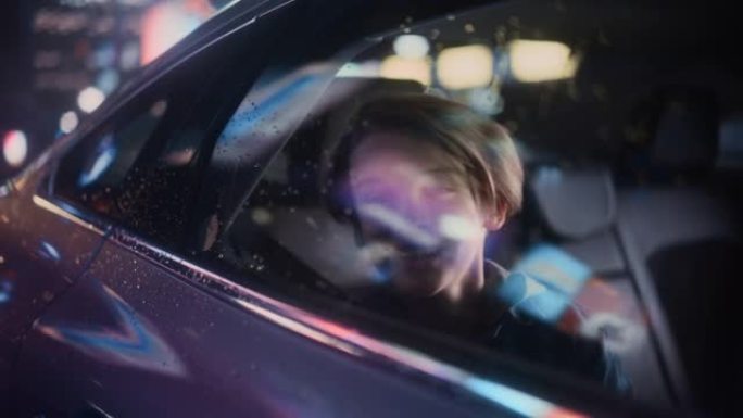 兴奋的小男孩坐在汽车后座上，晚上通勤回家。看着窗外，惊讶地发现带有工作霓虹灯的城市街道多么美丽。电影