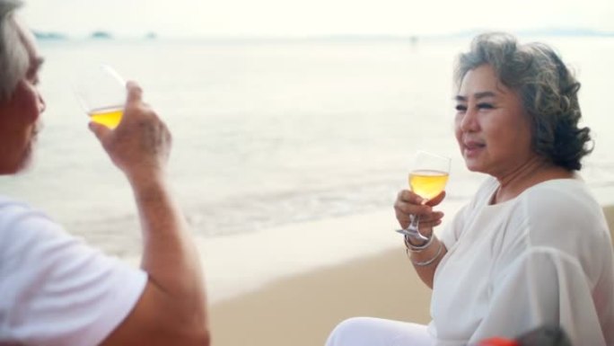 亚洲老年夫妇夏天在海滩度假时喜欢喝酒