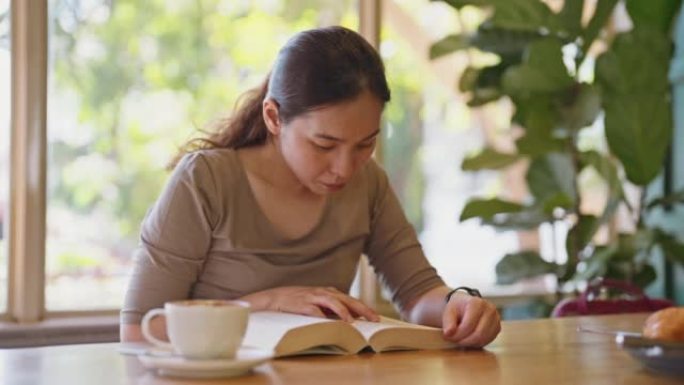 女人看书并在放松时间喝咖啡