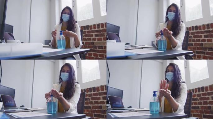 女人戴着口罩在办公室消毒双手