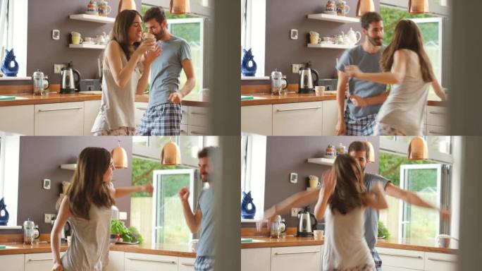 一对年轻夫妇在厨房里一起跳舞的4k视频片段