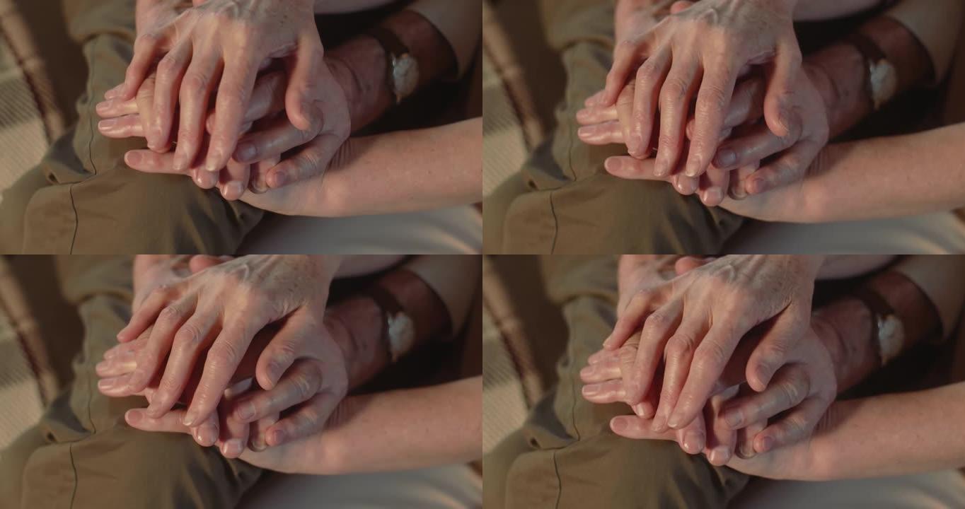 爱和关心。特写老年老年夫妇手牵手，支持着老年皱纹，互相照顾。