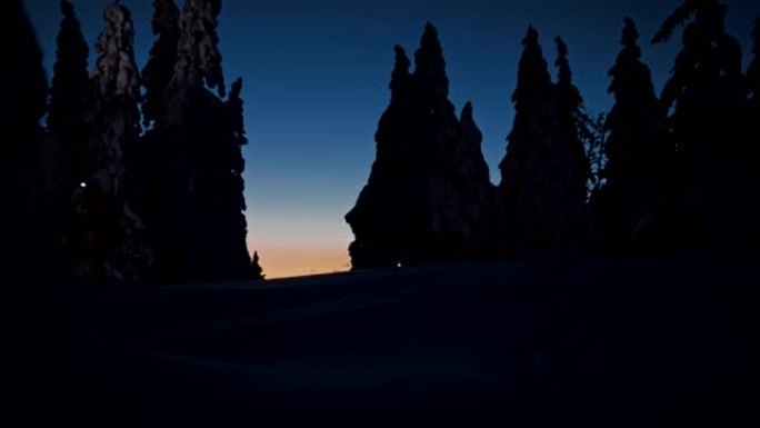 SLO MO两种越野滑雪者在夜间用大灯滑雪的剪影