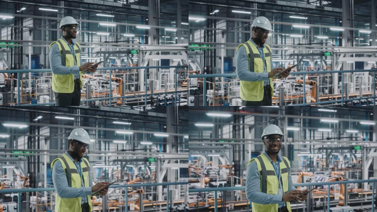 快乐的非洲裔美国汽车工厂工程师在高能见度背心使用平板电脑。在自动化技术装配厂从事汽车生产的汽车工业设