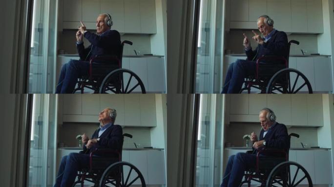 坐在轮椅上的快乐残疾老人的电影拍摄是在家里戴着耳机听音乐的同时跳舞和唱歌的乐趣。技术、障碍、联系、生