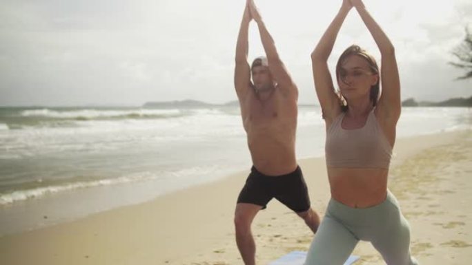 夫妇喜欢在海滩上练习户外瑜伽