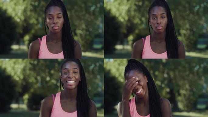 美丽的年轻黑人妇女微笑着绿色背景的肖像。快乐的非裔美国女少年在公园享受新鲜空气并嘲笑笑话