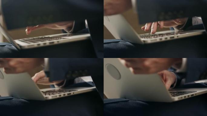 一个男人的手在一个灰色的银色笔记本电脑上打印，该笔记本电脑躺在一个男人的膝盖上，而相机从侧面到正面拍