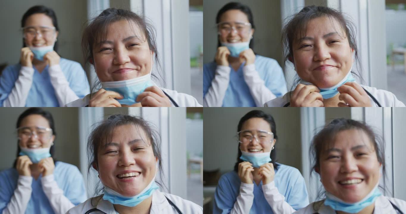 亚洲女护士和病人戴着口罩，放下口罩，对着镜头微笑的肖像