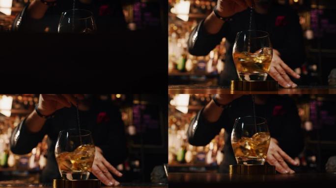 专业调酒师的特写镜头正在酒吧或迪斯科俱乐部为顾客混合酒精鸡尾酒和专业水晶持久冰块。
