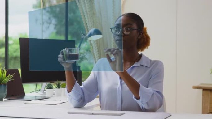 女人看着坐在办公桌上与AR技术互动的投影屏幕