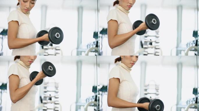 女人在健身馆用哑铃锻炼