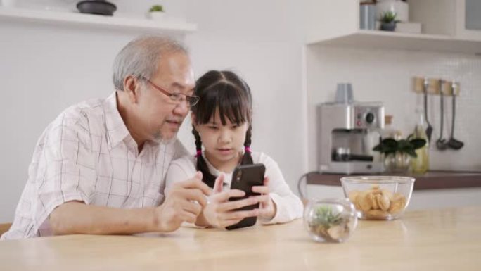 家庭祖父和孙子在家通过电话玩社交媒体。