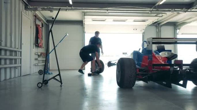 专家正在车库修理赛车的车轮