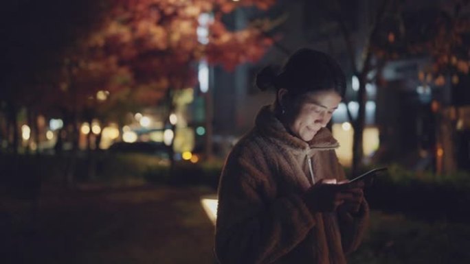 在韩国使用智能手机的亚洲女性快乐微笑。