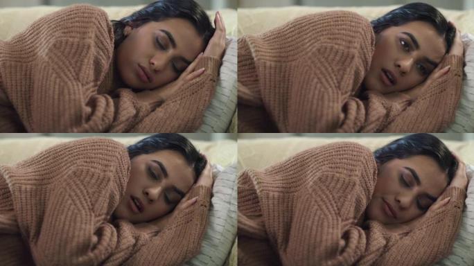 4k视频片段，一名年轻女子躺在家里的沙发上看起来筋疲力尽