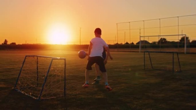 慢动作男孩在黄昏时在野外踢足球
