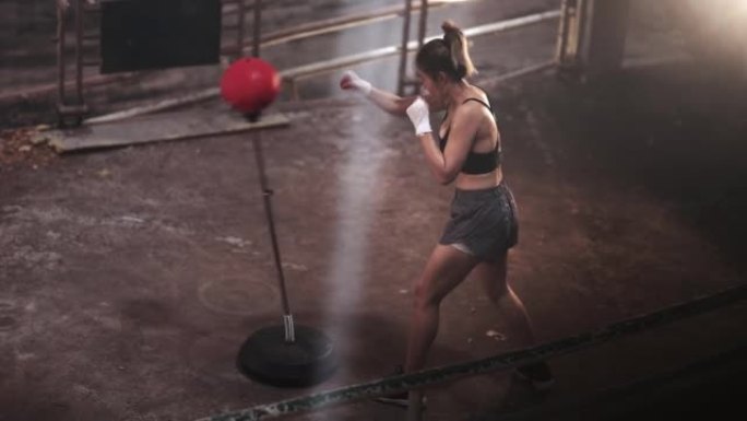 亚洲运动女运动员运动训练训练拳击在废弃的黑暗健身房