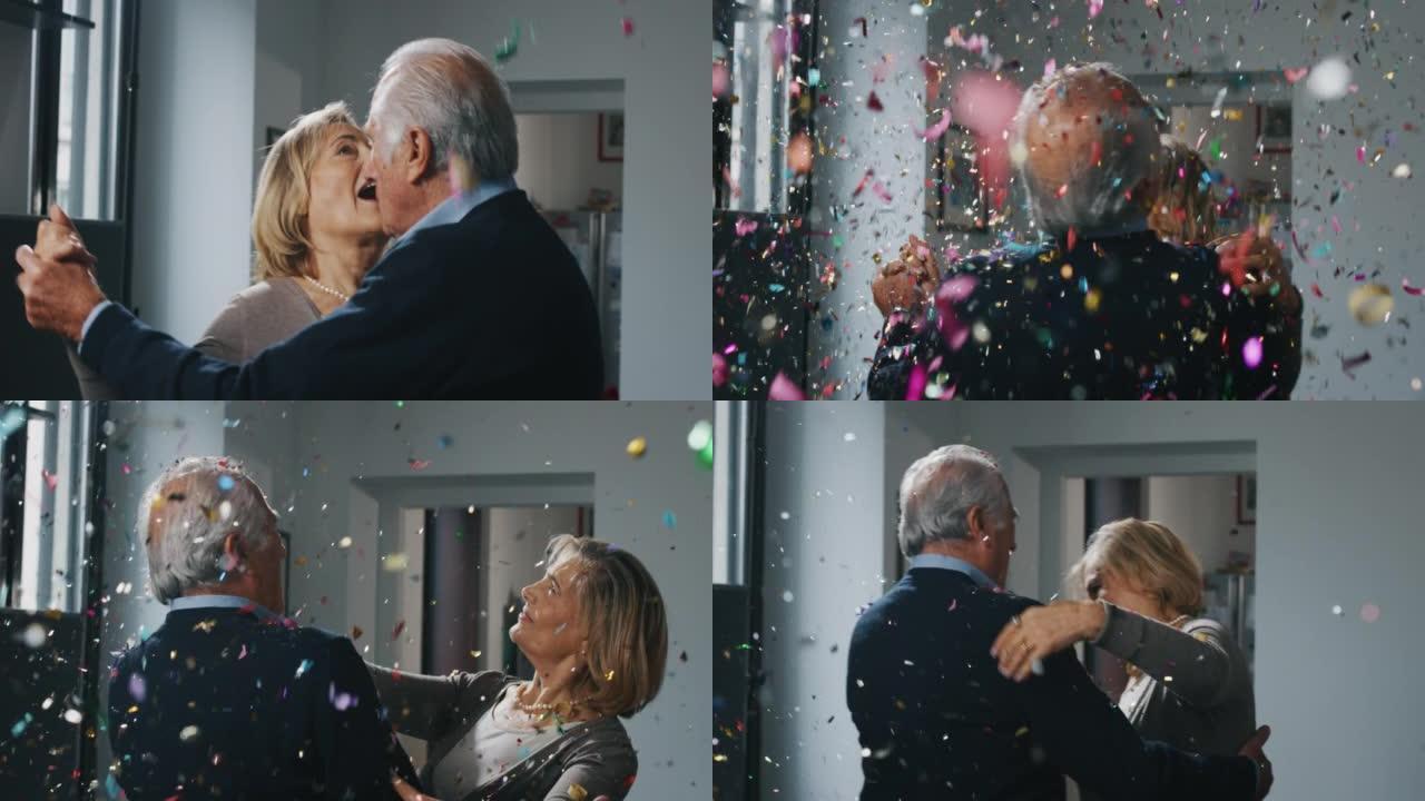 可爱的高级夫妇的特写镜头正在一起享受时光，在家里的客厅里跳舞，用五彩纸屑爆炸来庆祝他们永恒的爱。