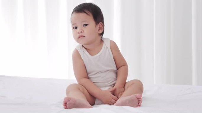 亚洲男婴年龄9个月在卧室里。东南亚和东亚: 亚洲婴儿