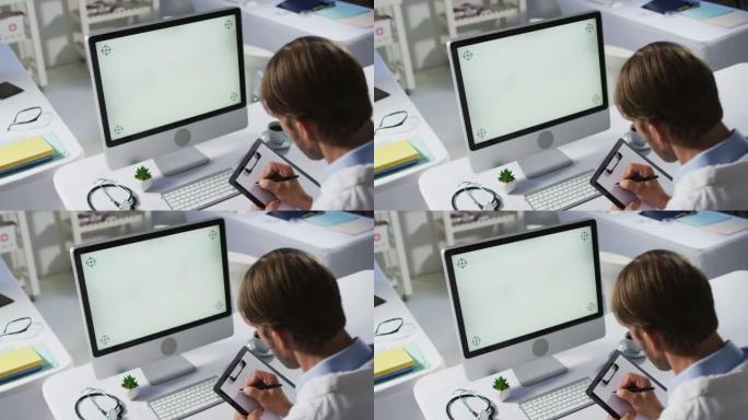 高加索男医生使用台式计算机进行视频通话咨询并做笔记