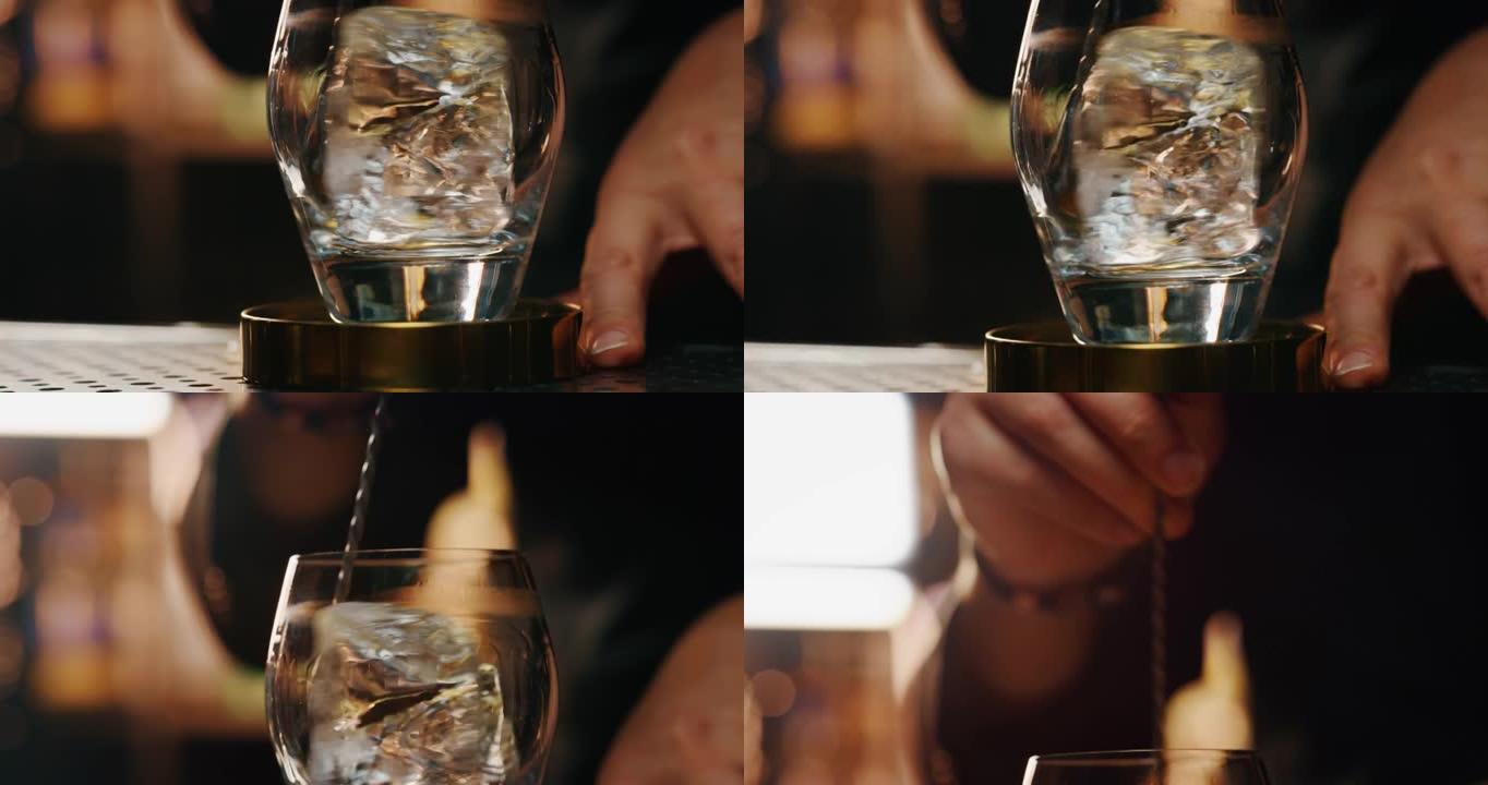 专业调酒师的特写镜头是在酒吧或迪斯科俱乐部为顾客准备酒精鸡尾酒的同时，将专业水晶持久冰块混合在玻璃杯