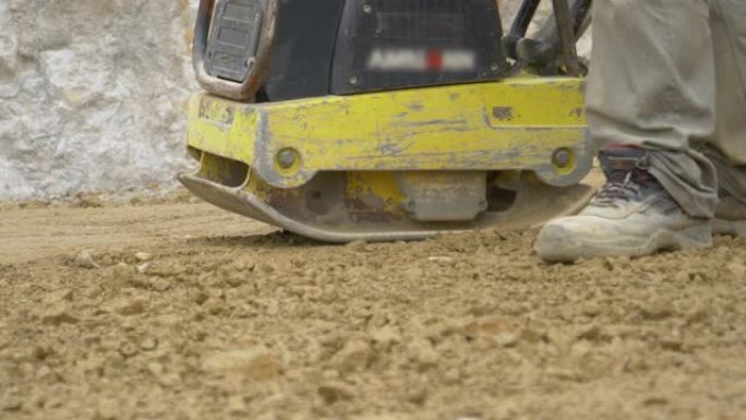特写: 工人使用找平机为混凝土浇筑准备地面