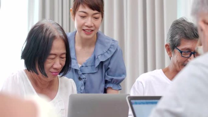 一群年龄在60-70岁之间的亚洲高级学生，他们参加了针对初学者的计算机培训课程，这是他们高级成人教育