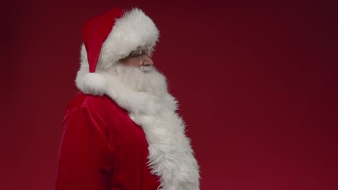 在红色背景上半转过圣诞老人，我们从后面看到他，然后他转过身，竖起大拇指，右边是复制空间，