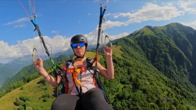 POV女人在飞行滑翔伞时欣赏群山美景