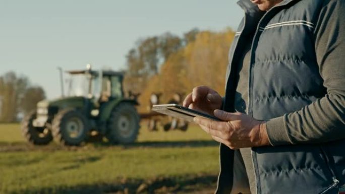 SLO MO在田里使用数字平板电脑的农民
