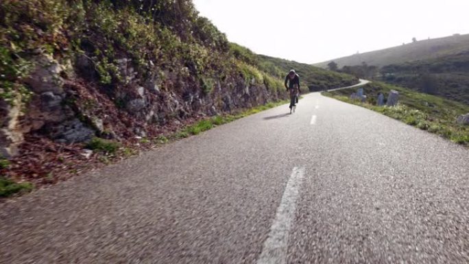 男子骑车人骑运动自行车在山路快速上坡