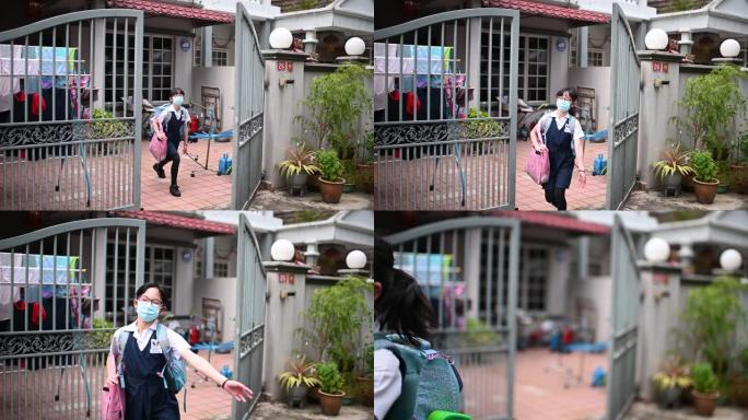 一个戴着口罩上学的亚洲中国小女孩走出家门成为新常态