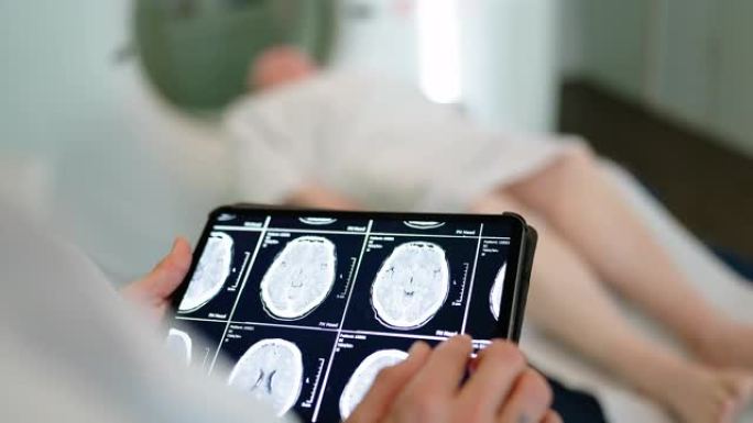 医生在诊所的数字桌子上检查患者的MRI扫描图像的特写